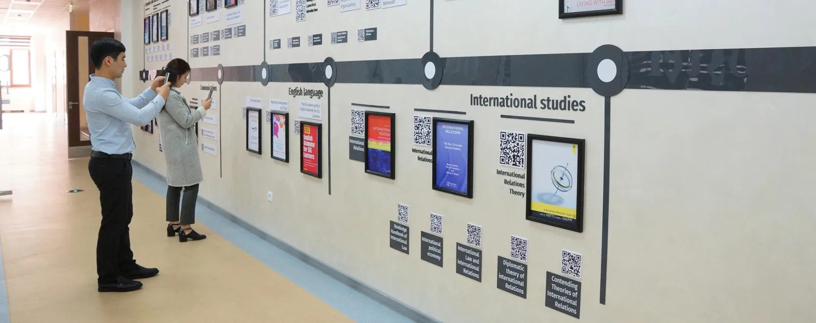 Two students interact with information wall.