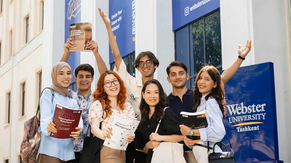 Several students standing in front of Tashkent building on campus.