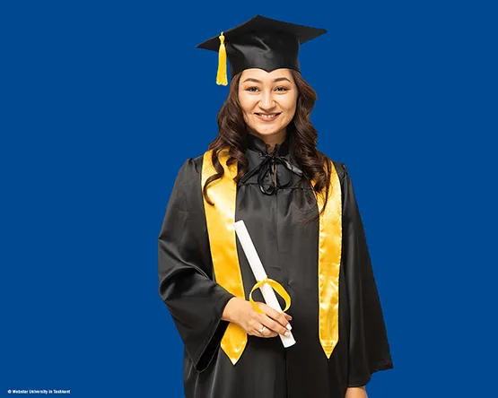 MBA Alumna Tursunoy Usmnonova looks into the camera in her commencement gown